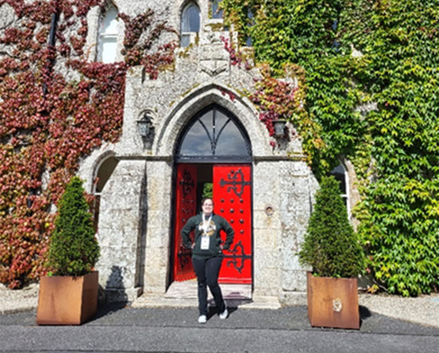 student posing in front of Barretstown castle