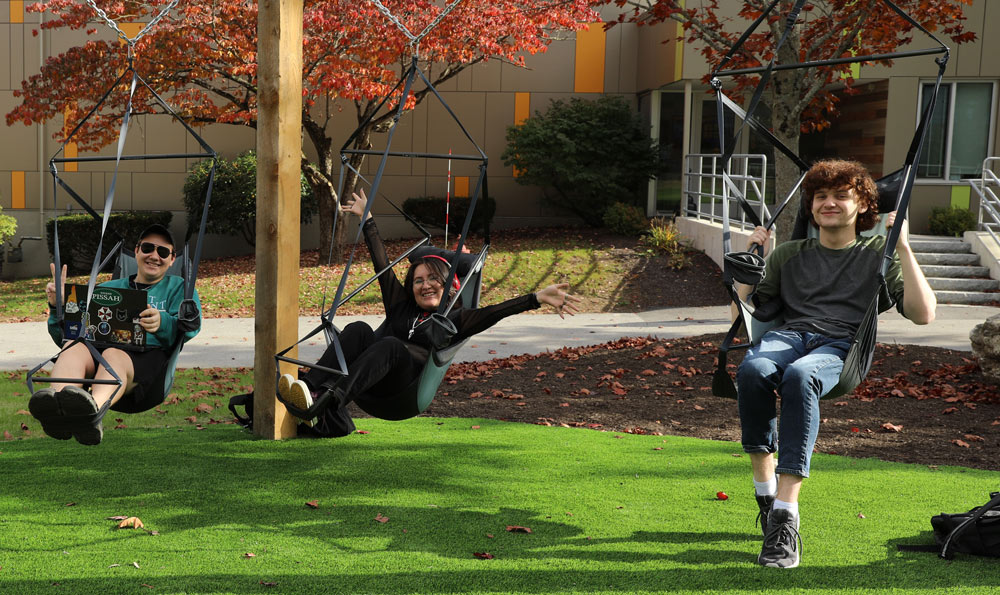 students hanging out on community hammocks and swings on the new Kingston Green Space