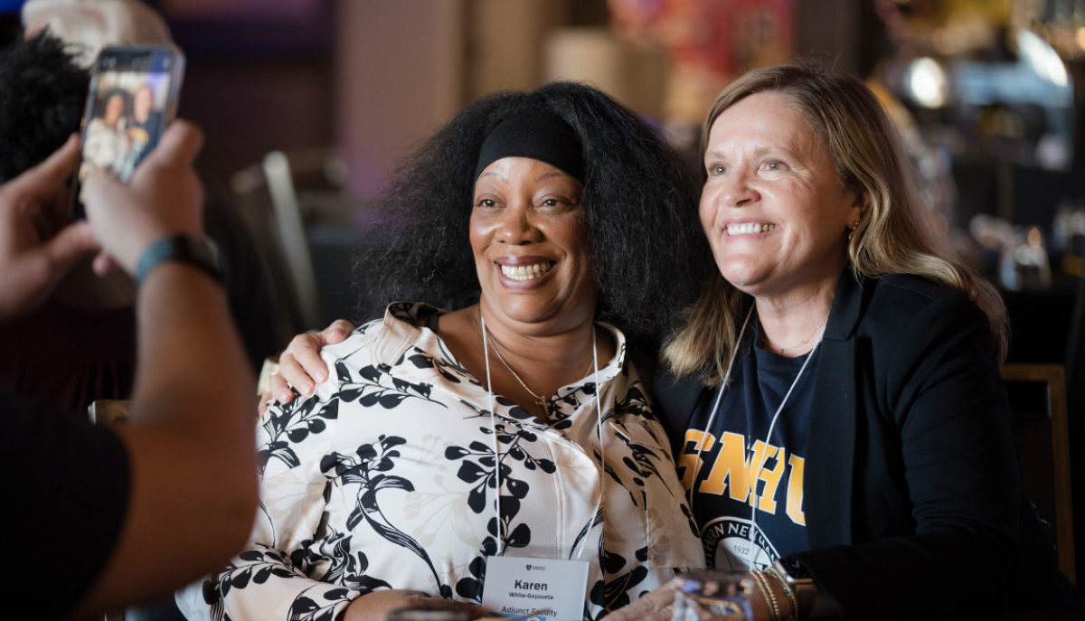 two women hugging and smiling for a photo