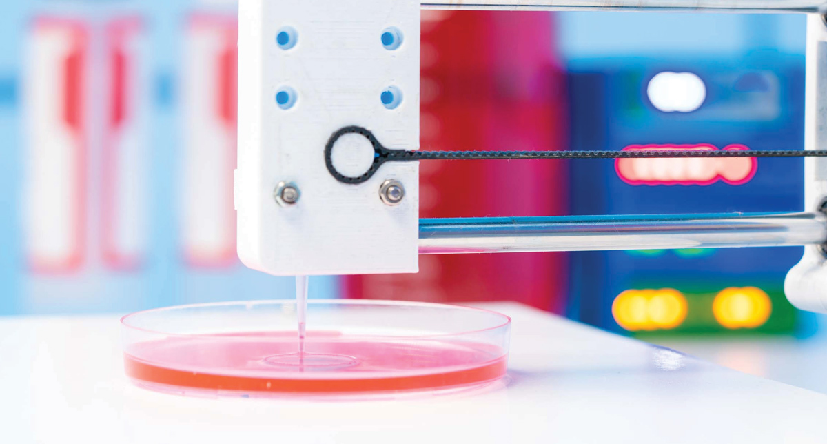 3D printer nozzle above a Petri dish with pink liquid, against a colorful laboratory background.